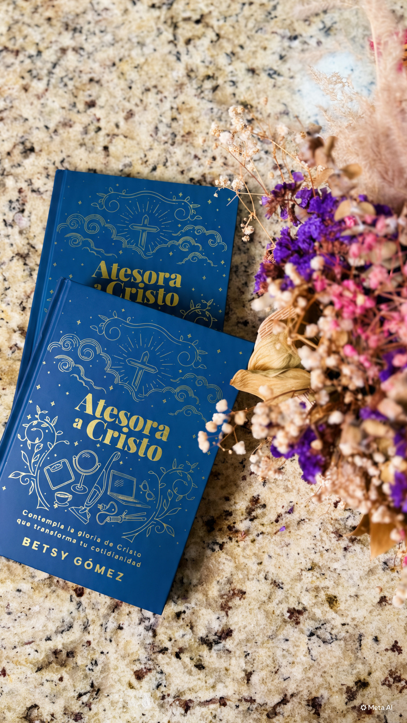 Dos ejemplares de Atesora a Cristo sobre una mesa junto a flores